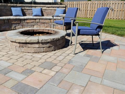 Backyard patio with brick fireplace and bench